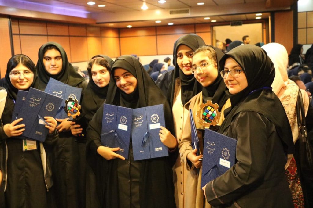 دانش آموز دختر ایرانی در حال گرفتن جایزه